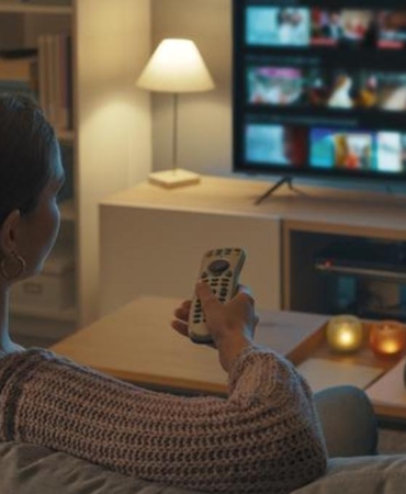 Woman watching TV at home and relaxing